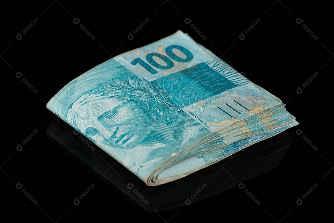 Dinheiro brasileiro. Notas de cem reais com fundo preto