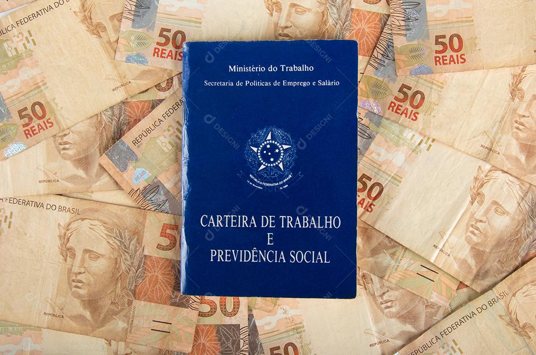 Carteira de Trabalho e Previdência Social com cédulas de dinheiro brasileiras.