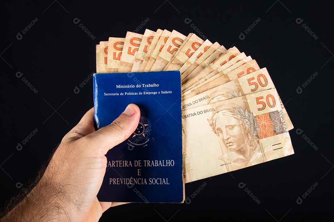 Mão segurando trabalho de documento brasileiro e previdência social (Carteira de trabalho)