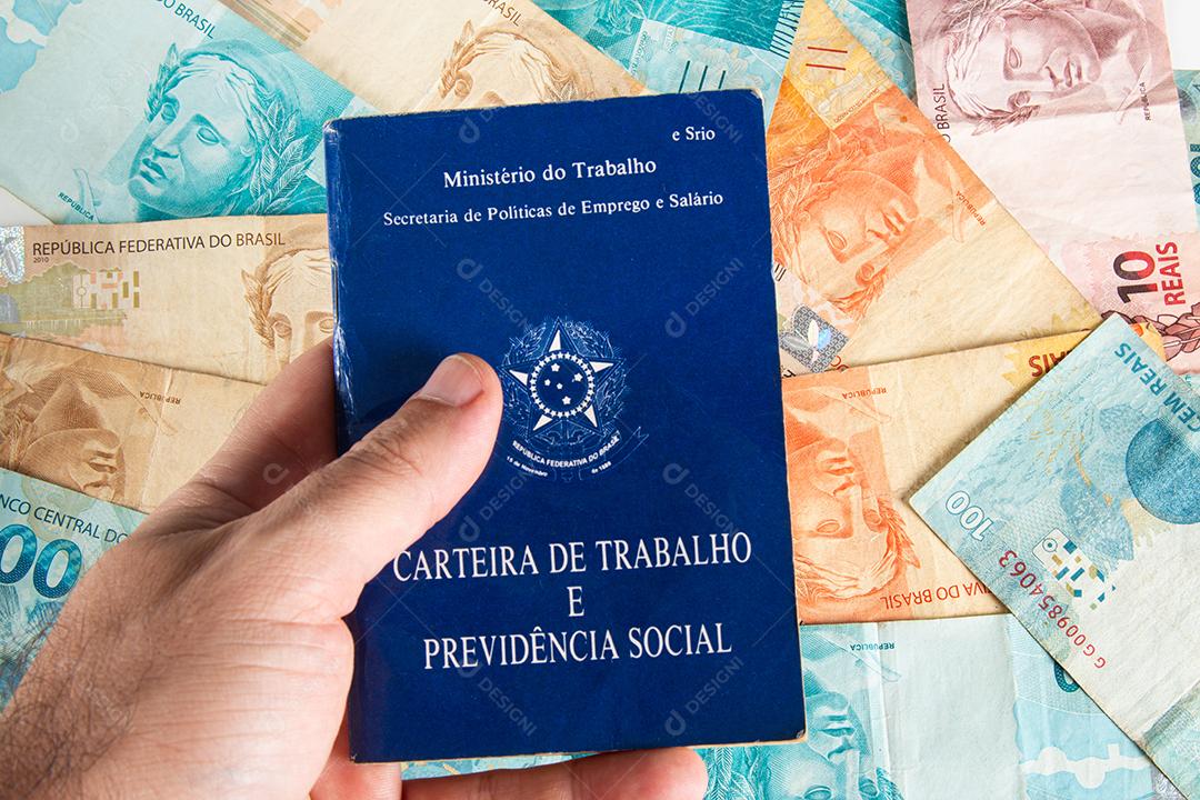 Mão segurando trabalho de documento brasileiro e previdência social (Carteira de trabalho)