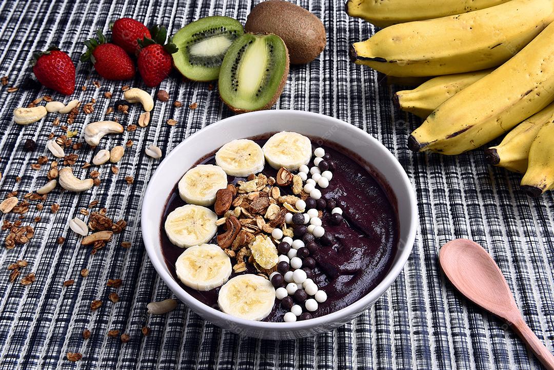 Tigela de smoothie de açaí com morangos, bananas, kiwis e granola