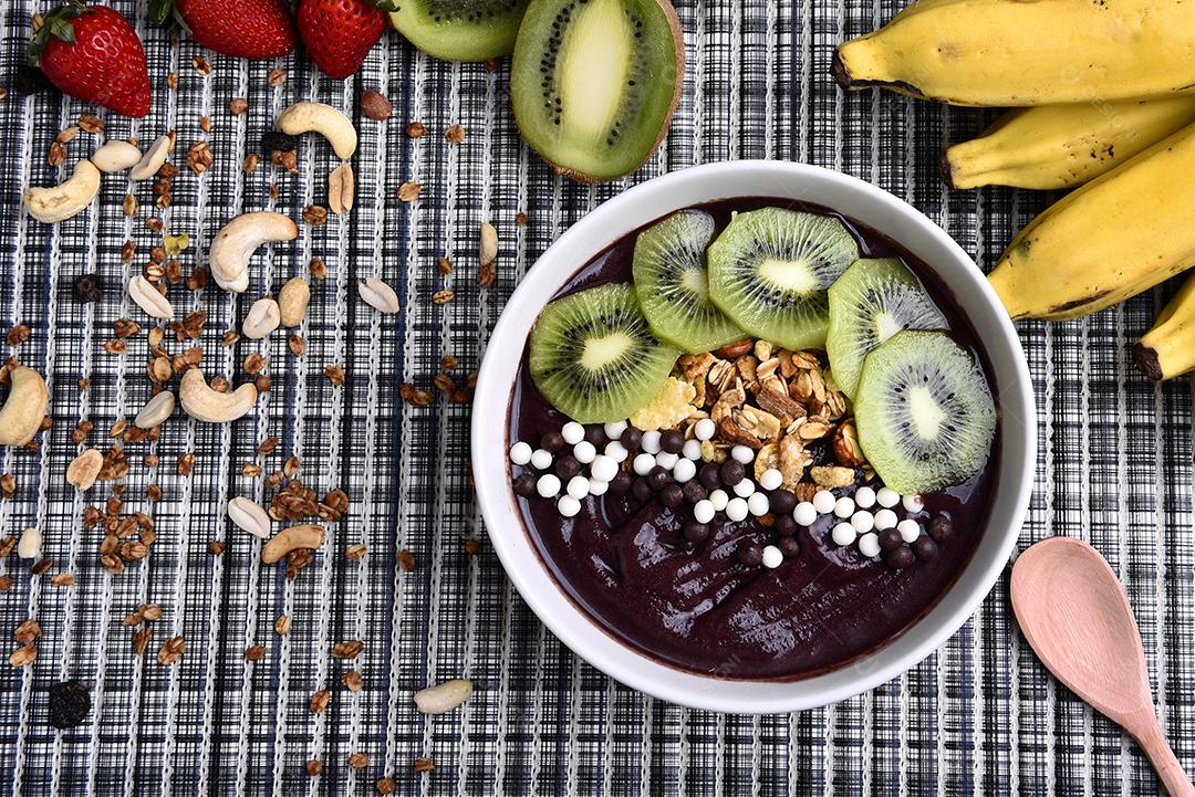 Tigela de smoothie de açaí com morangos, bananas, kiwis e granola
