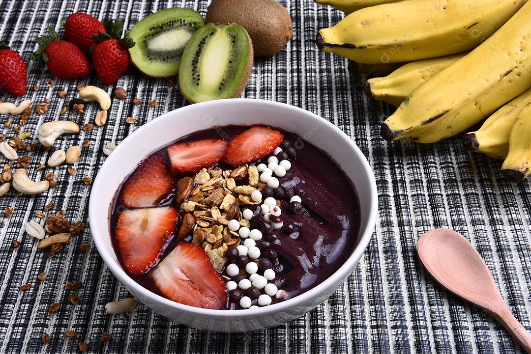 Tigela de smoothie de açaí com morangos, bananas, kiwis e granola