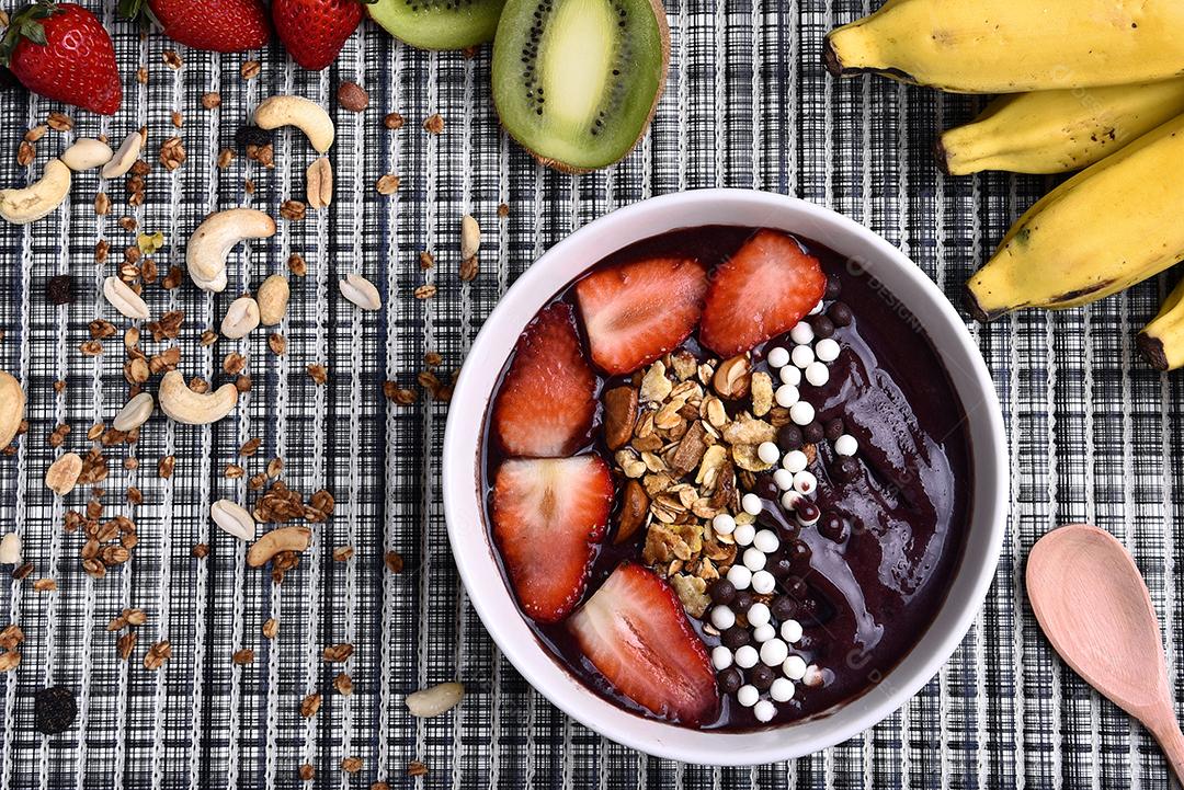 Tigela de smoothie de açaí com morangos, bananas, kiwis e granola