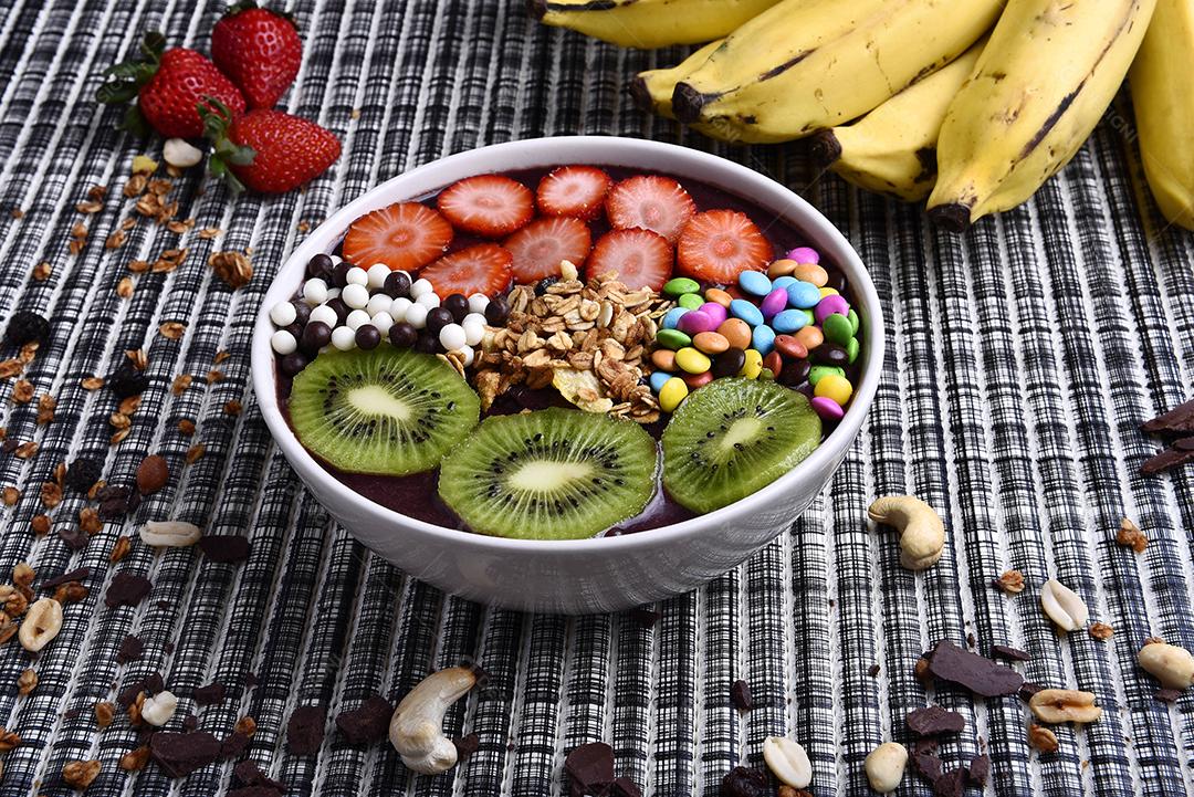 Tigela de smoothie de açaí com morangos, bananas, kiwis e granola