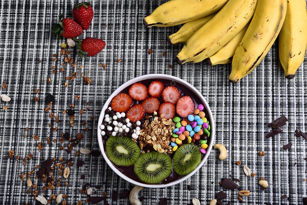 Tigela de smoothie de açaí com morangos, bananas, kiwis e granola