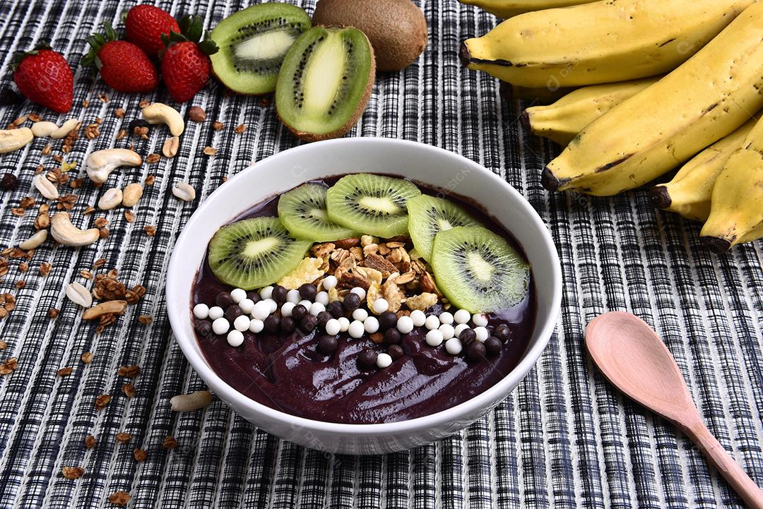 Tigela de smoothie de açaí com morangos, bananas, kiwis e granola