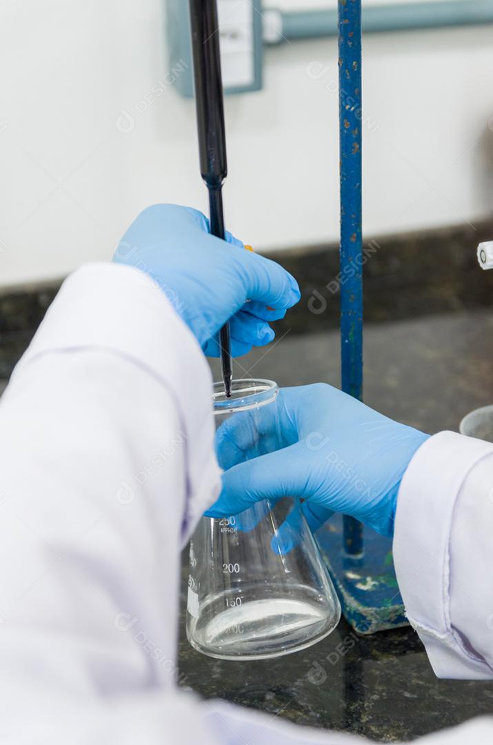 Mãos de mulher realizando teste de titulação no controle de qualidade química.