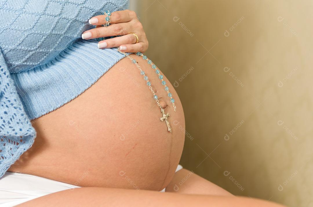 Gravidez, descanso, pessoas e conceito de expectativa - mulher grávida feliz sentada na cama e tocando sua barriga