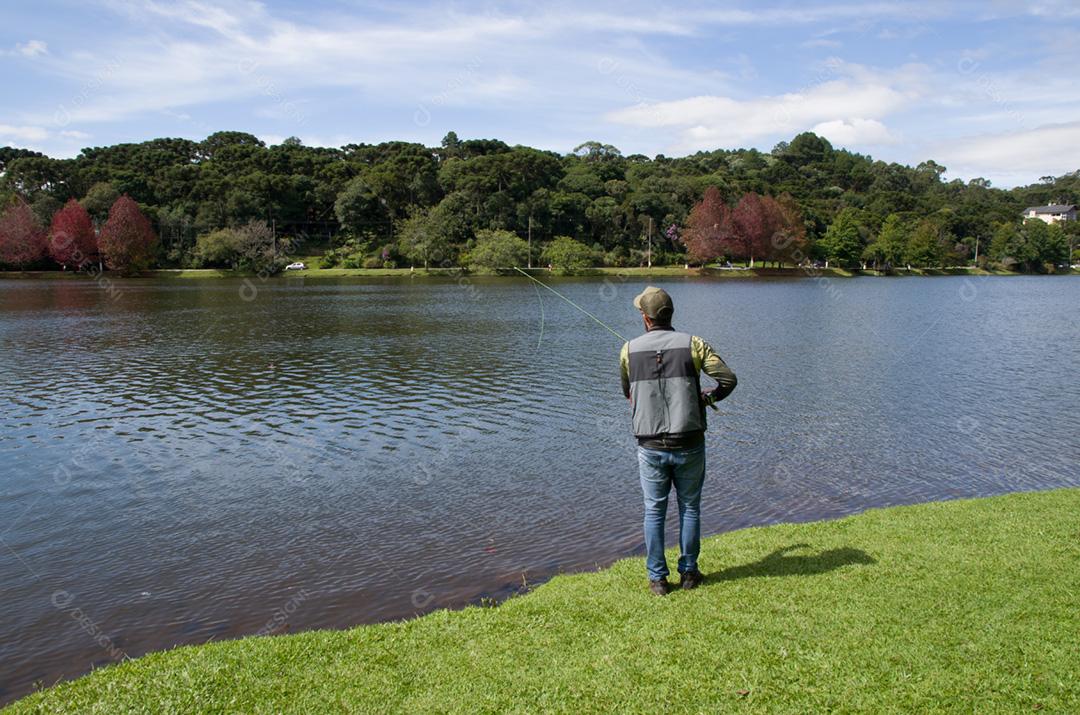 Flyfishing no lago no Brasil, pesca de jovem pescador.