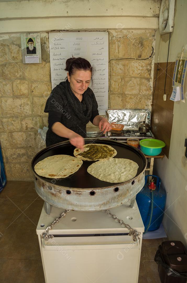 Mulher libanesa preparando uma comida típica libanesa, preparando o Zaatar Manoucher.