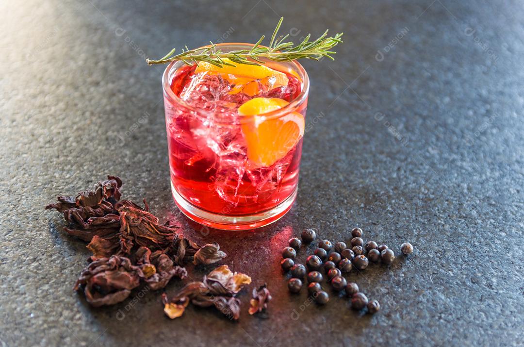Lindo coquetel de kombucha de hibisco com gin e vodka, decorado com ramo de alecrim.