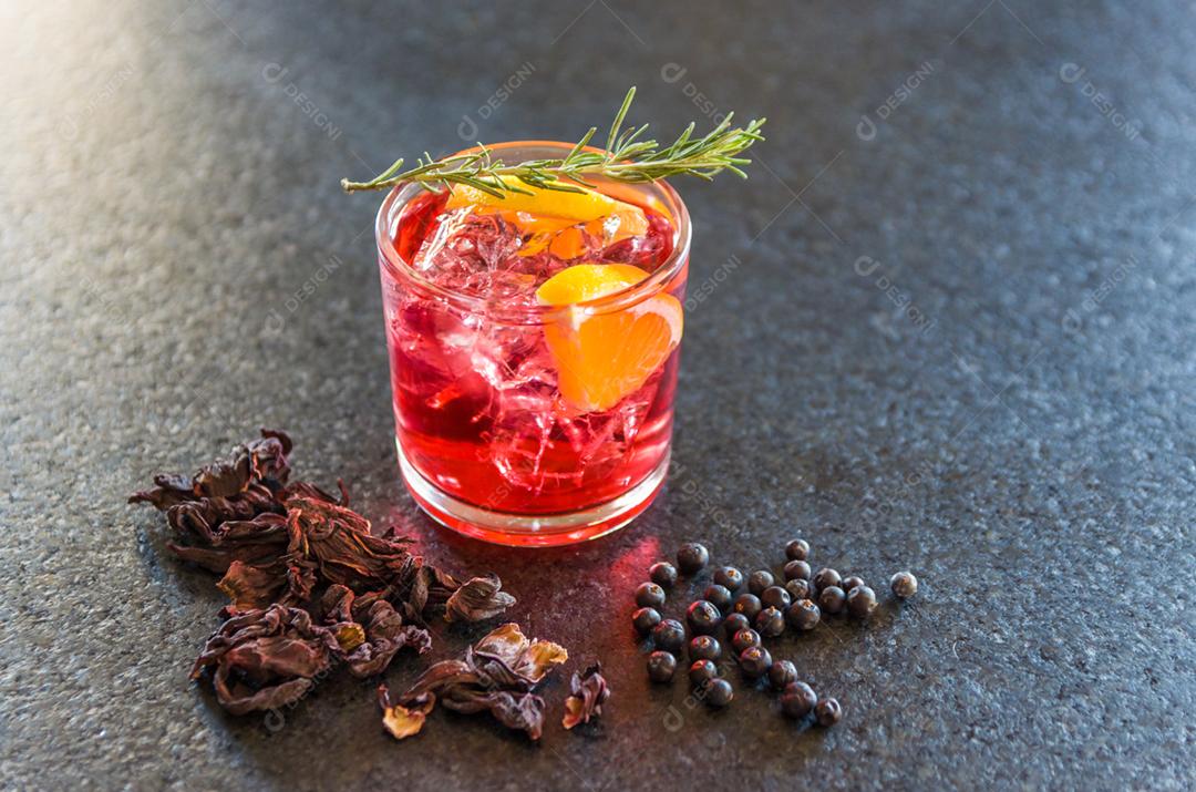 Lindo coquetel de kombucha de hibisco com gin e vodka, decorado com ramo de alecrim.
