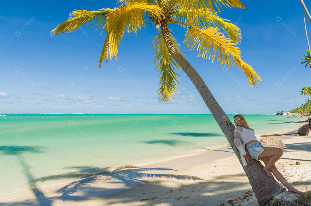 Jovem turista deitada em coqueiro na praia paradisíaca do Brasil, Praia dos Carneiros, Pernambuco, Brasil.