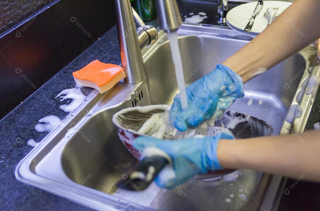 Limpando a louça, panela na pia.