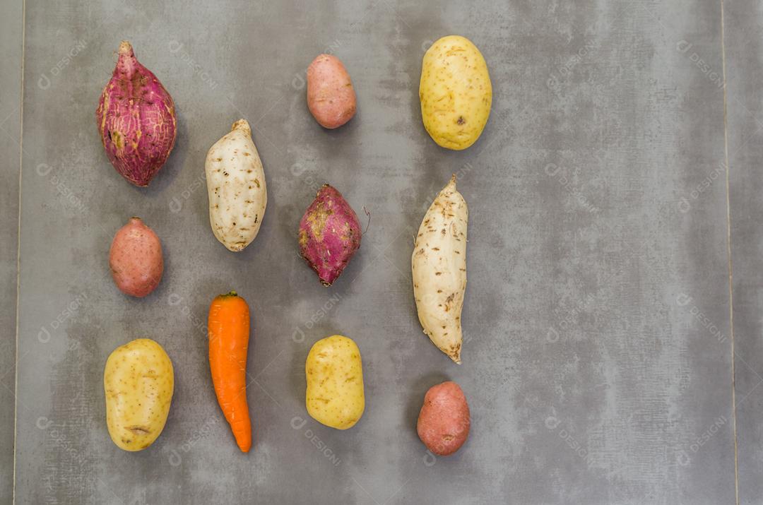 Grande conceito de comida saudável, vários vegetais, batatas, batatas doces, cenouras, em fundo cinza