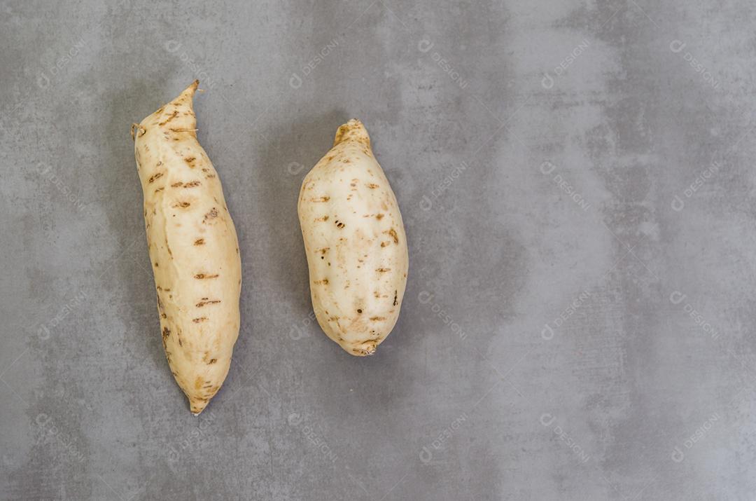 Grande conceito de alimentação saudável, batata-doce em fundo cinza, concreto polido.