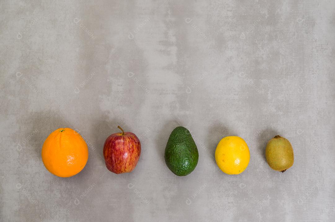 Grande conceito de alimentação saudável, várias frutas em fundo cinza, concreto polido. Laranja, maçã, kiwi, limão.