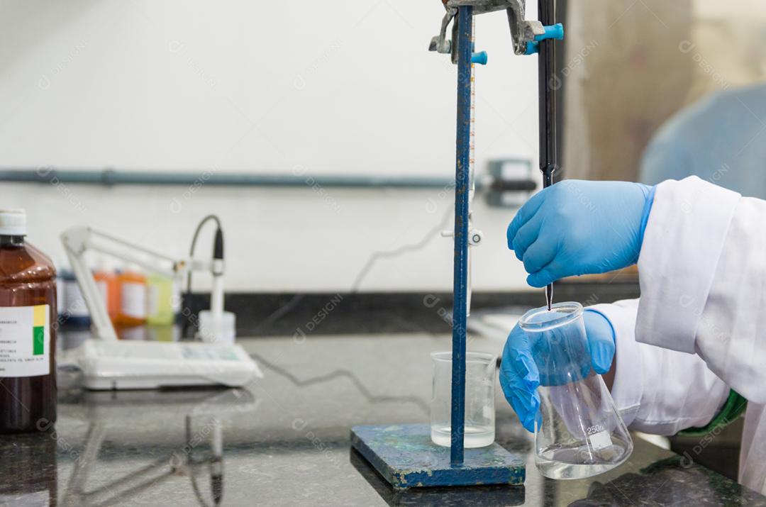 Mãos de mulher realizando teste de titulação no controle de qualidade química.