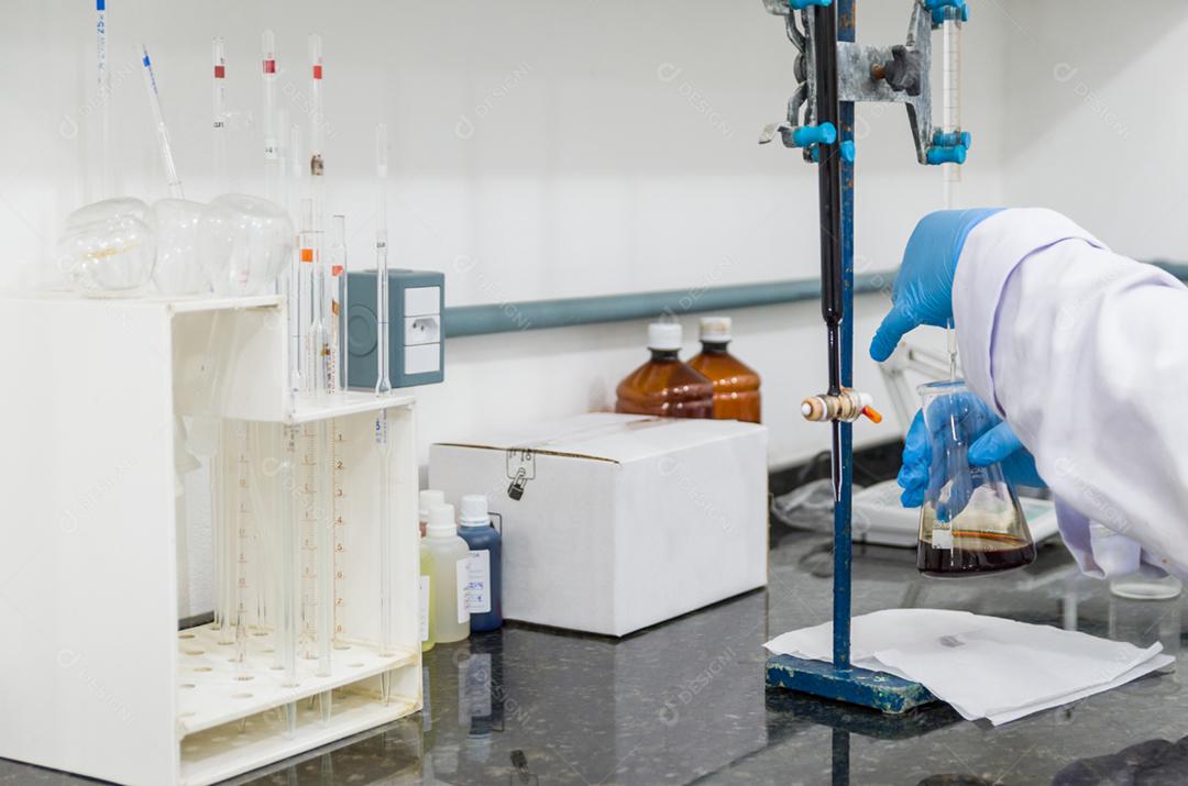 Mãos de mulher realizando teste de titulação no controle de qualidade química.