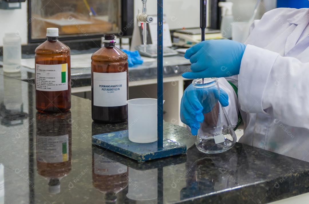 Mãos de mulher realizando teste de pH no instrumento eletrônico do medidor de pH para controle de qualidade na indústria química.