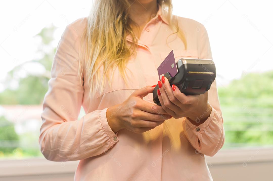 Grande conceito de pagamento com cartão de crédito, jovem caucasiana fazendo pagamento com cartão de crédito na máquina.