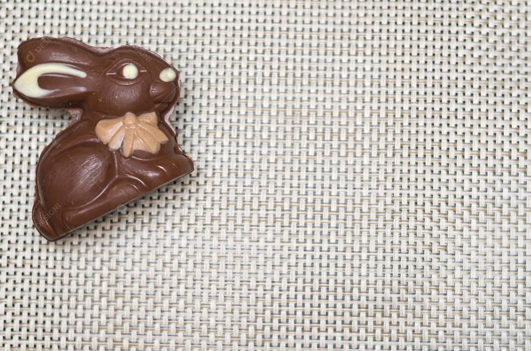 Conceito de Páscoa, coelhinho da Páscoa de pelúcia em fundo de palha com ovos decorados e coloridos.