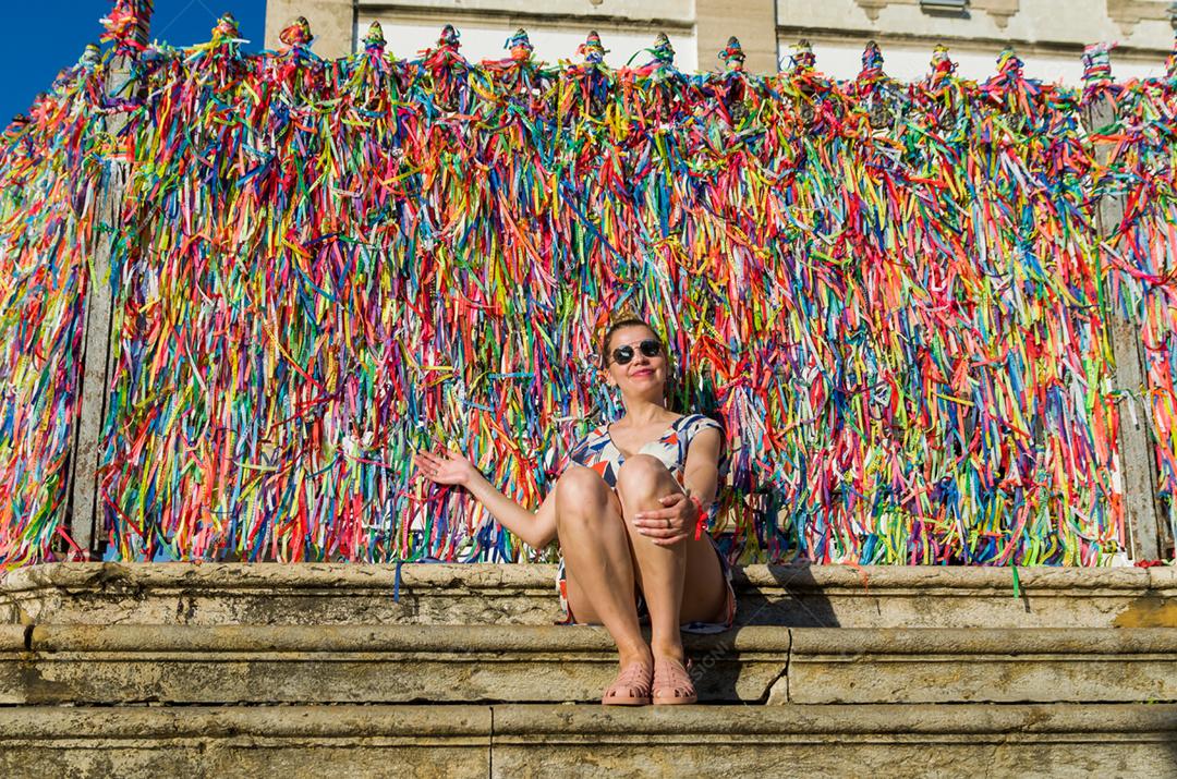 Garota na frente da grade com fitas coloridas da igreja do Bonfim em Salvador Bahia Brasil