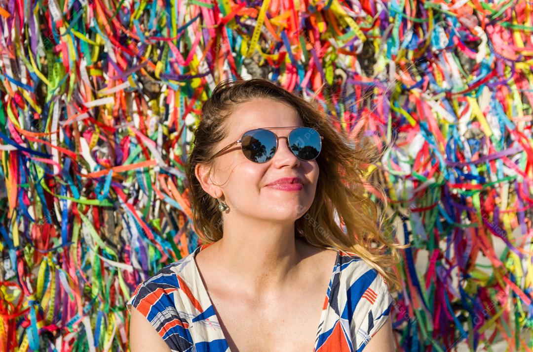 Garota na frente da grade com fitas coloridas da igreja do Bonfim em Salvador Bahia Brasil
