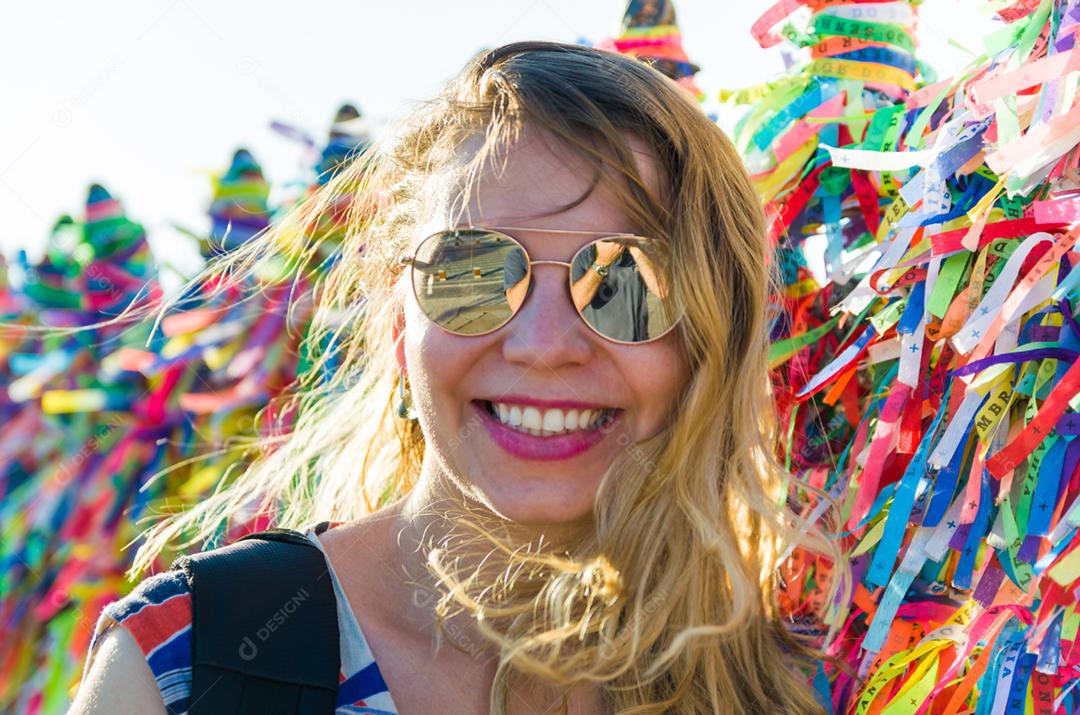 Garota na frente da grade com fitas coloridas da igreja do Bonfim em Salvador Bahia Brasil