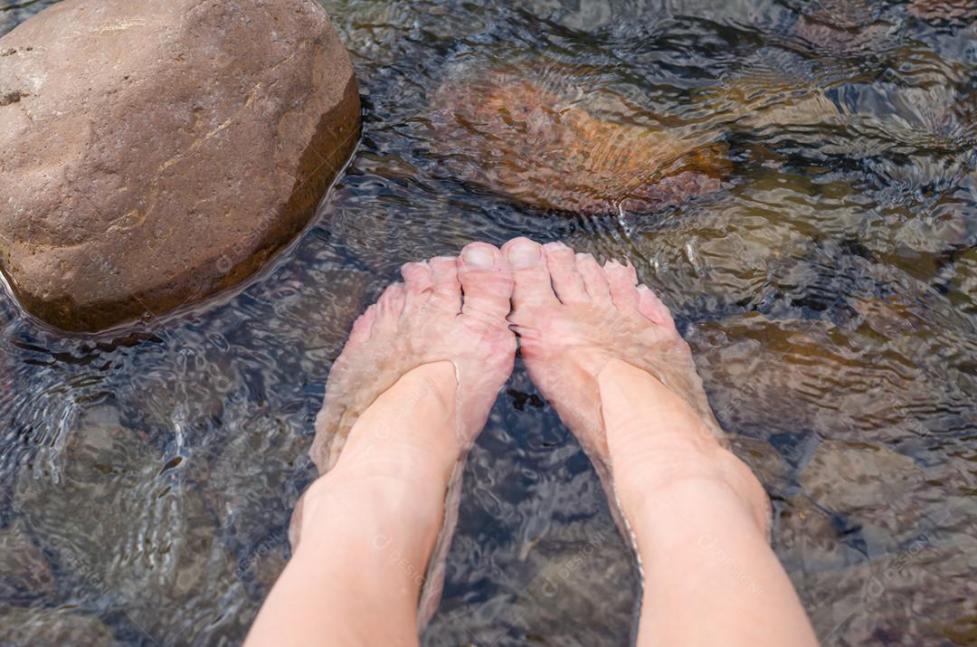 Grande conceito de relaxamento, pernas de mulher na pedra na praia