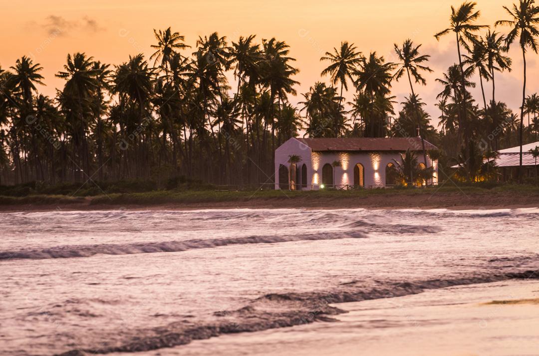 Bela imagem da praia de São Miguel dos Milagres com sua famosa igreja ao pôr do sol, localizada no estado de Alagoas no Brasil.