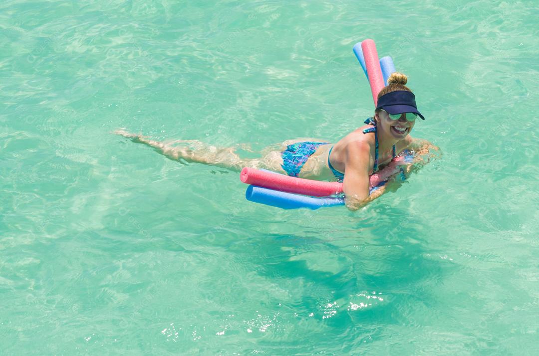 Jovem turista loira tomando banho de mar na paradisíaca praia de Maragogi, Brasil.