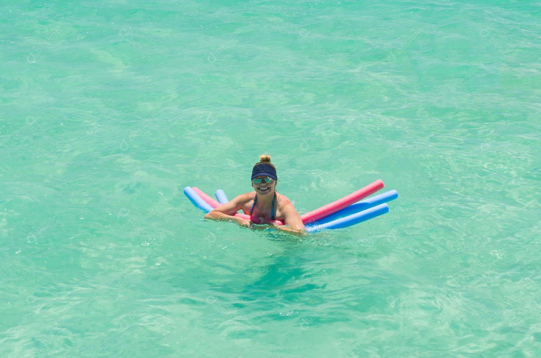 Jovem turista loira tomando banho de mar na paradisíaca praia de Maragogi, Brasil.