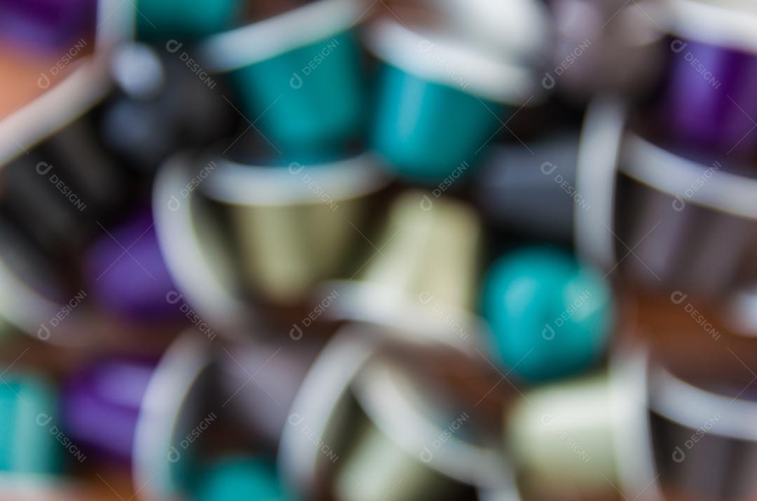 Cápsulas de café expresso coloridas, máquina de café, sobre fundo de madeira.