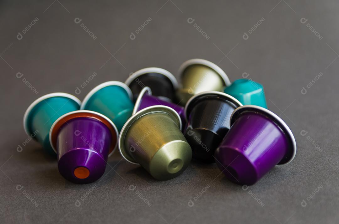 Cápsulas de café expresso coloridas, máquina de café, sobre fundo de madeira.