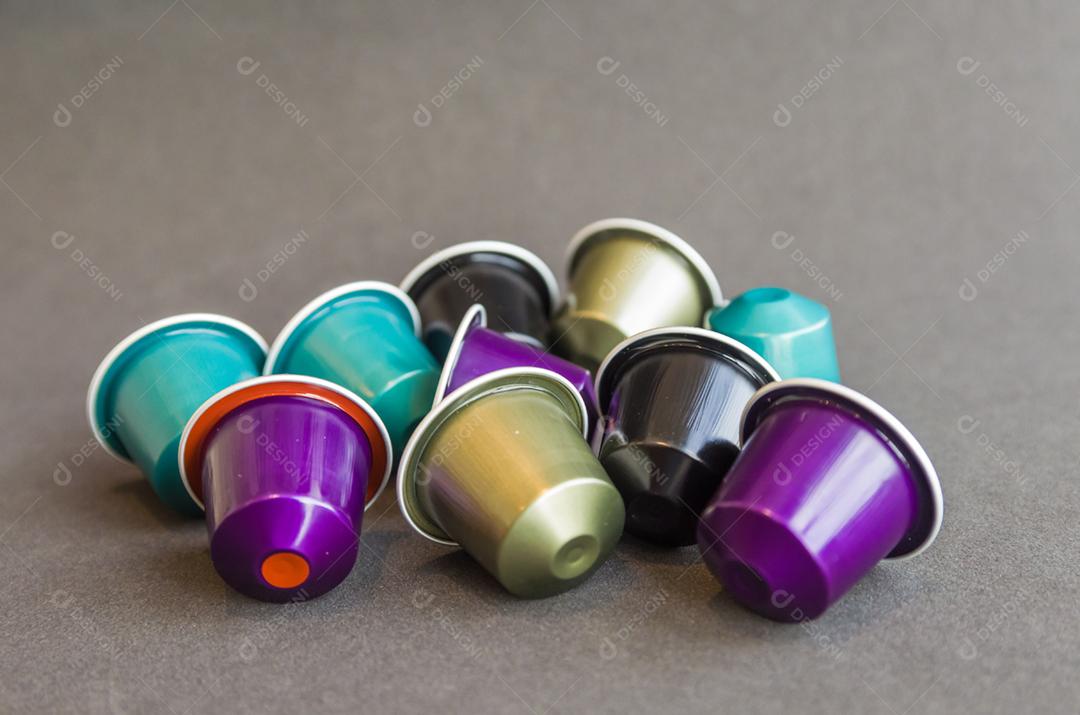 Cápsulas de café expresso coloridas, máquina de café, sobre fundo de madeira.