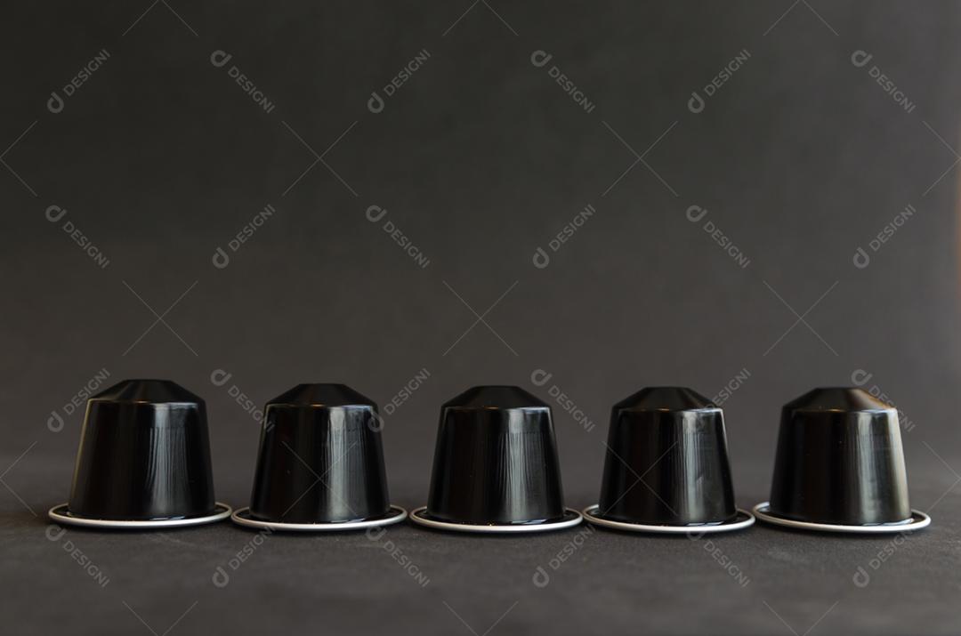 Cápsulas de café expresso coloridas, máquina de café, sobre fundo de madeira.