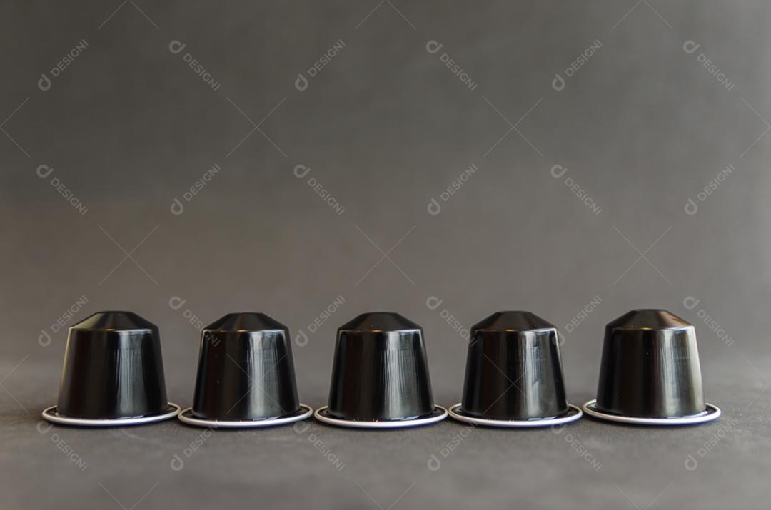 Cápsulas de café expresso coloridas, máquina de café, sobre fundo de madeira.