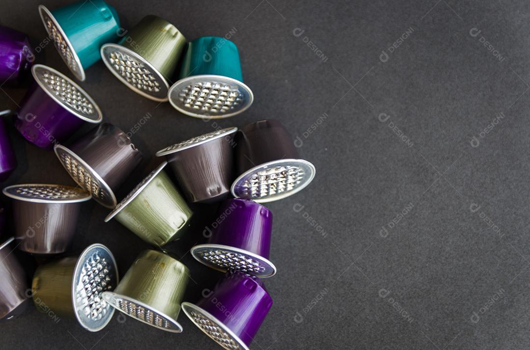 Cápsulas de café expresso coloridas usadas em fundo preto, reciclagem, meio ambiente.