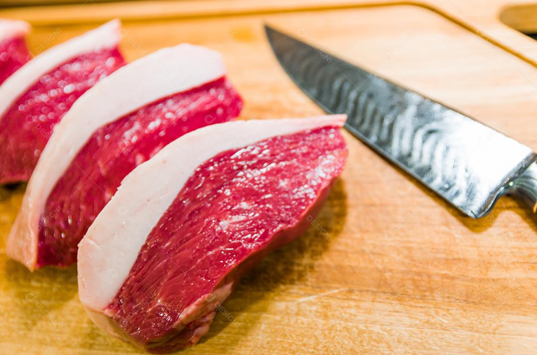 Linda foto de cortes de Picanha em uma tábua de madeira e uma linda faca de aço damasco personalizada