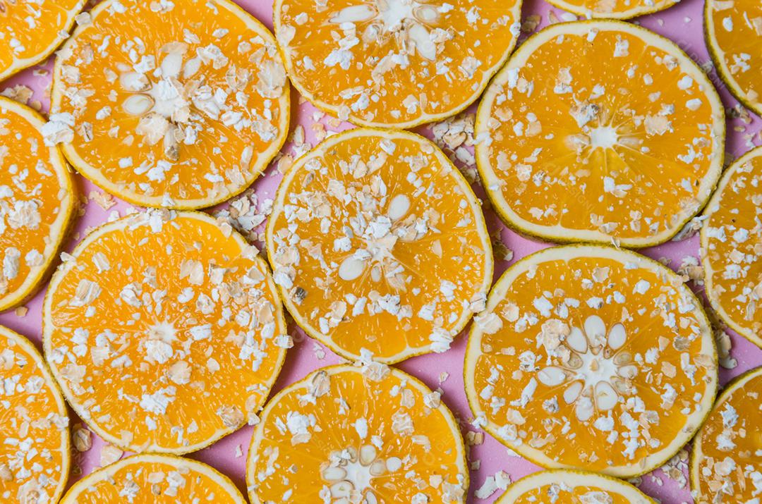 Beautiful texture of sliced orange with oat flakes on pink background