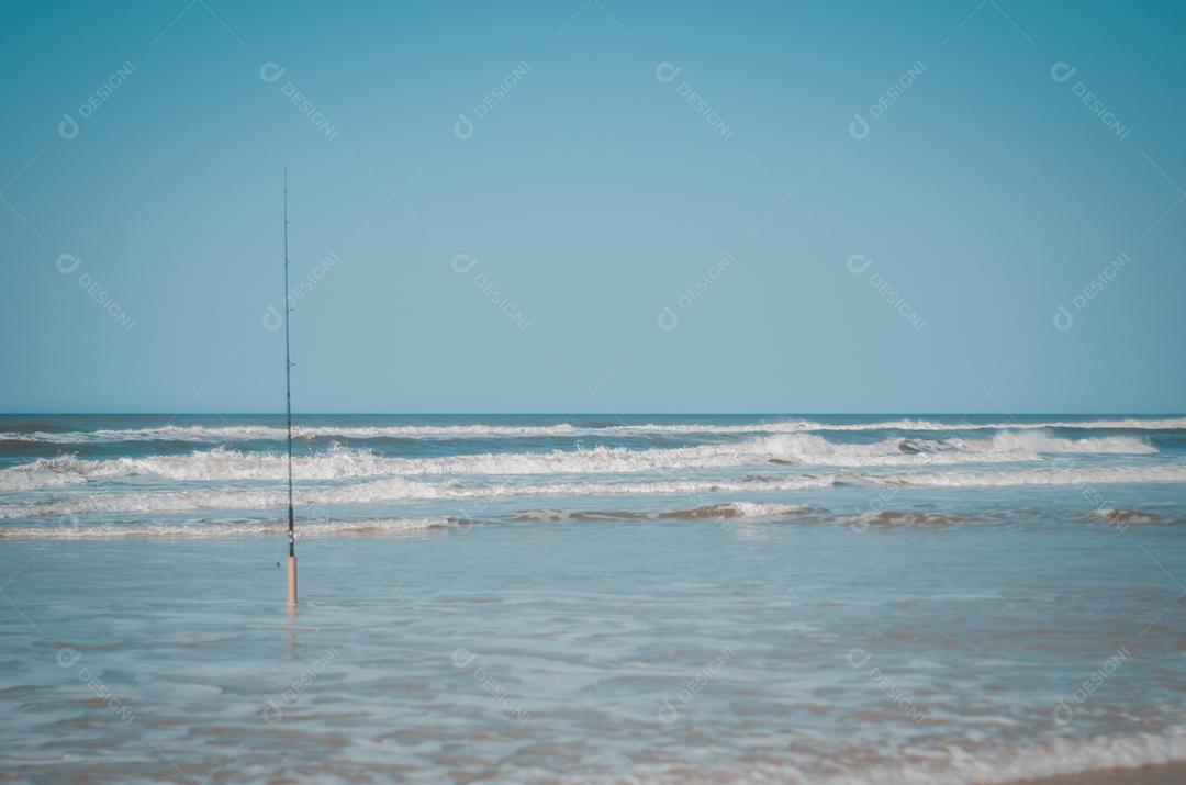 Pesca na praia, vara de pescar na areia da praia.