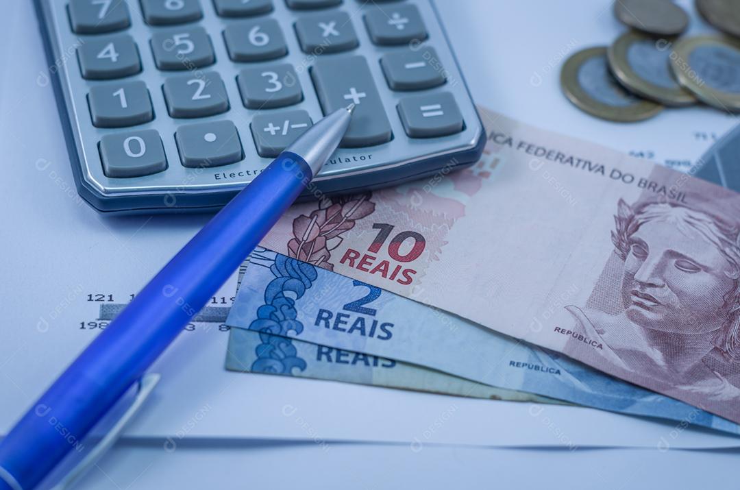 Caneta, gráficos, calculadora, cartão de crédito e dinheiro brasileiro (real), conceito de finanças