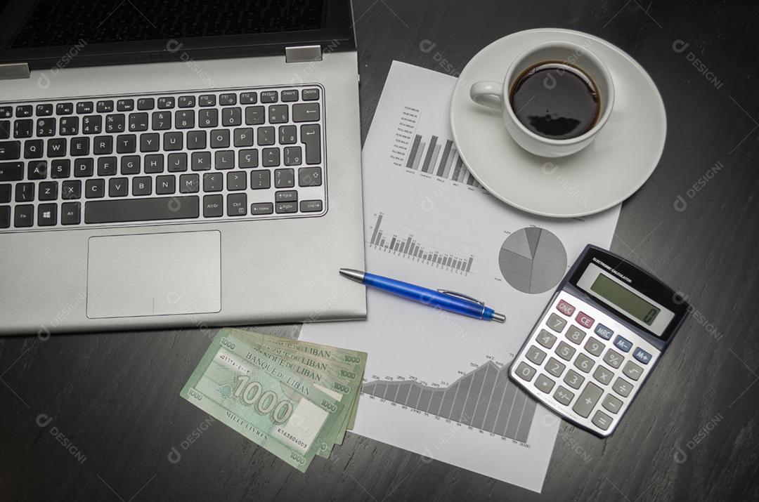 Laptop, xícara de café, caneta, calculadora, gráficos e dinheiro Libra libanesa, conceito de finanças