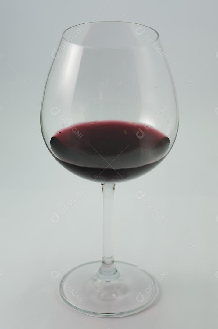 Grande copo de vinho sendo servido com vinho tinto