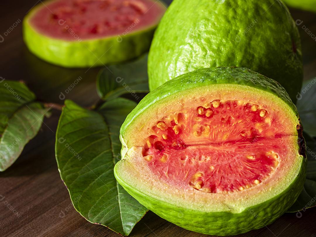 Linda goiaba vermelha fresca, fruta de outono em fundo rústico de madeira