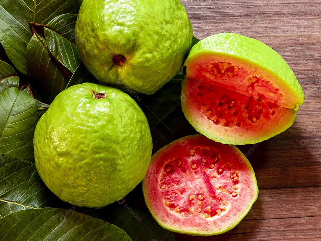 Linda goiaba vermelha fresca, fruta de outono em fundo rústico de madeira