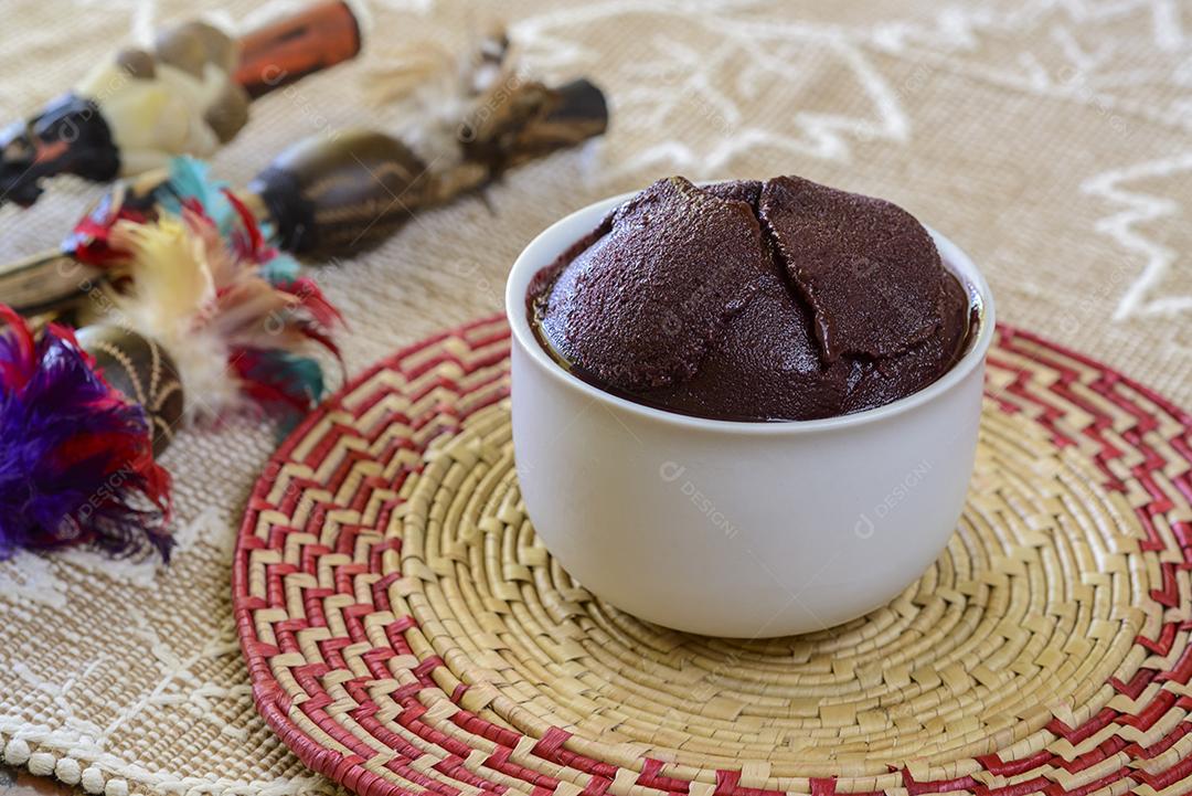 Açaí. Tigela de açaí brasileiro em uma mesa com artesanato da região amazônica borrada ao fundo.