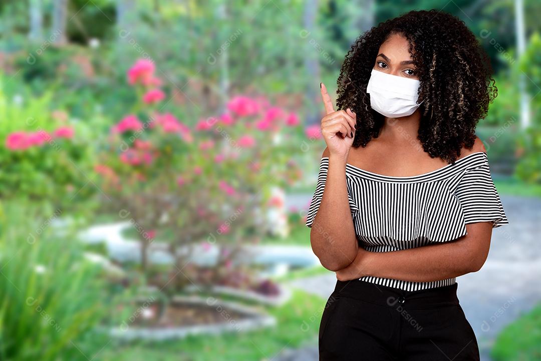 Retrato ao ar livre de uma jovem negra com proteção médica